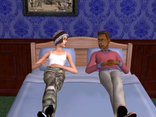 Joan and Damion chatting on the bed